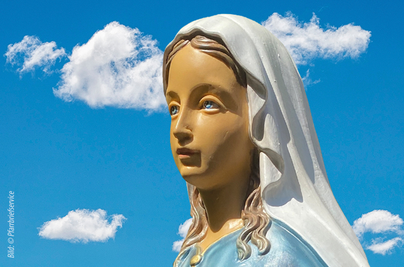 Statue (Kopf) von Jungfrau Maria vor einem Himmel mit Wolken