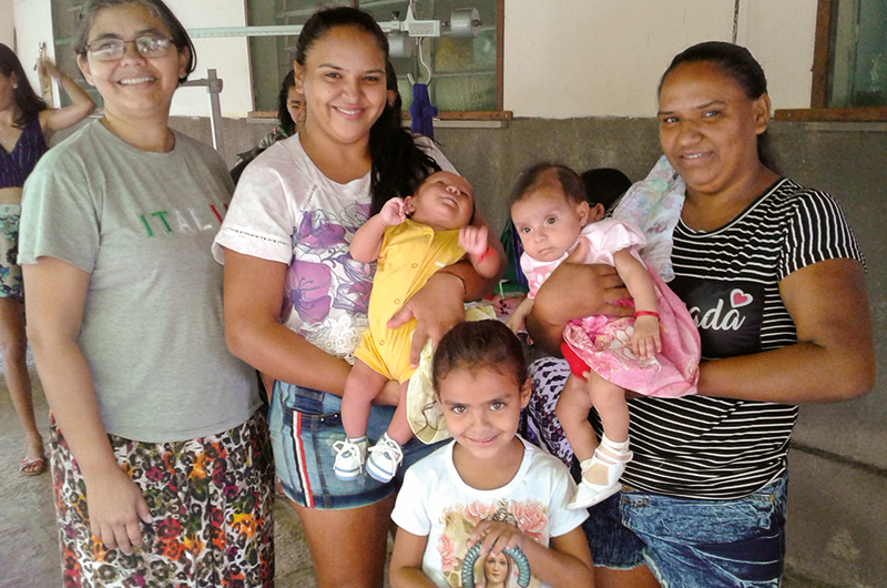Frauen mit Babys auf dem Arm, ein Kleinkind im Vordergrund