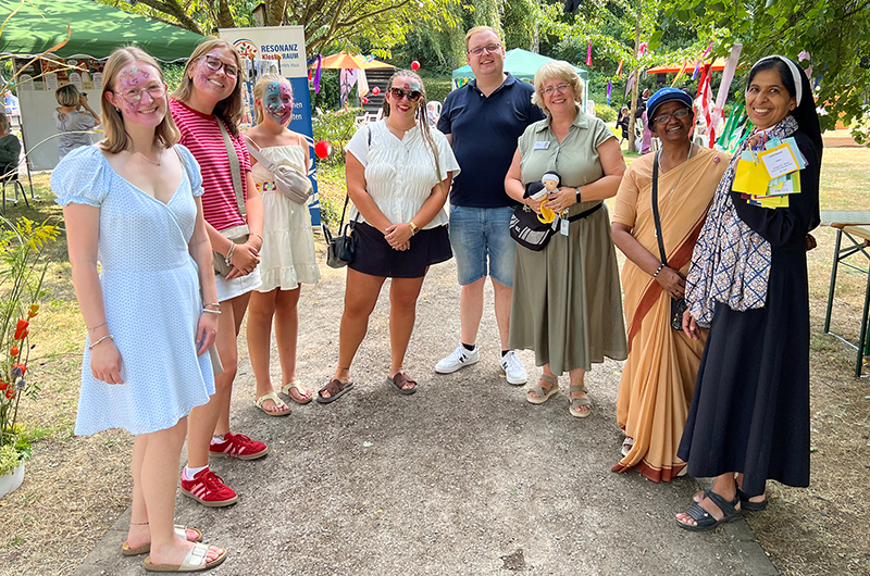 Eine Menschengruppe im grünen Klosterpark