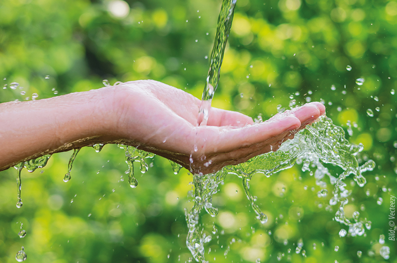 Ausgestreckte Hand, über die Wasser läuft; Hintergrund ist grün