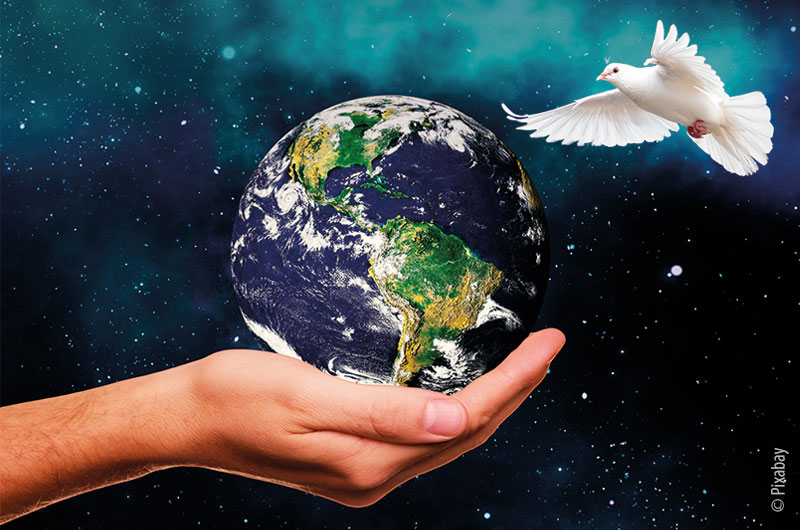 Bildmontage: Hand, die einen Globus hält, daneben fliegt eine weiße Taube, im Hintergrund das All